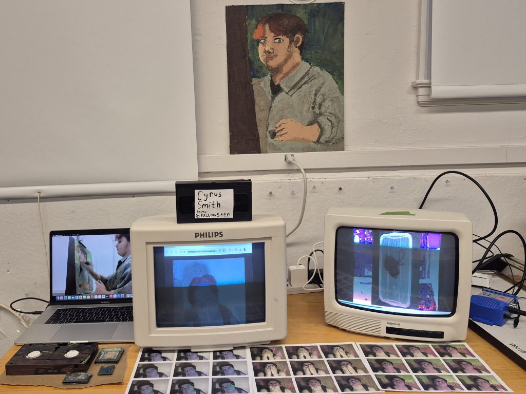 Picture of multiple screens show different videos with a painting above them.