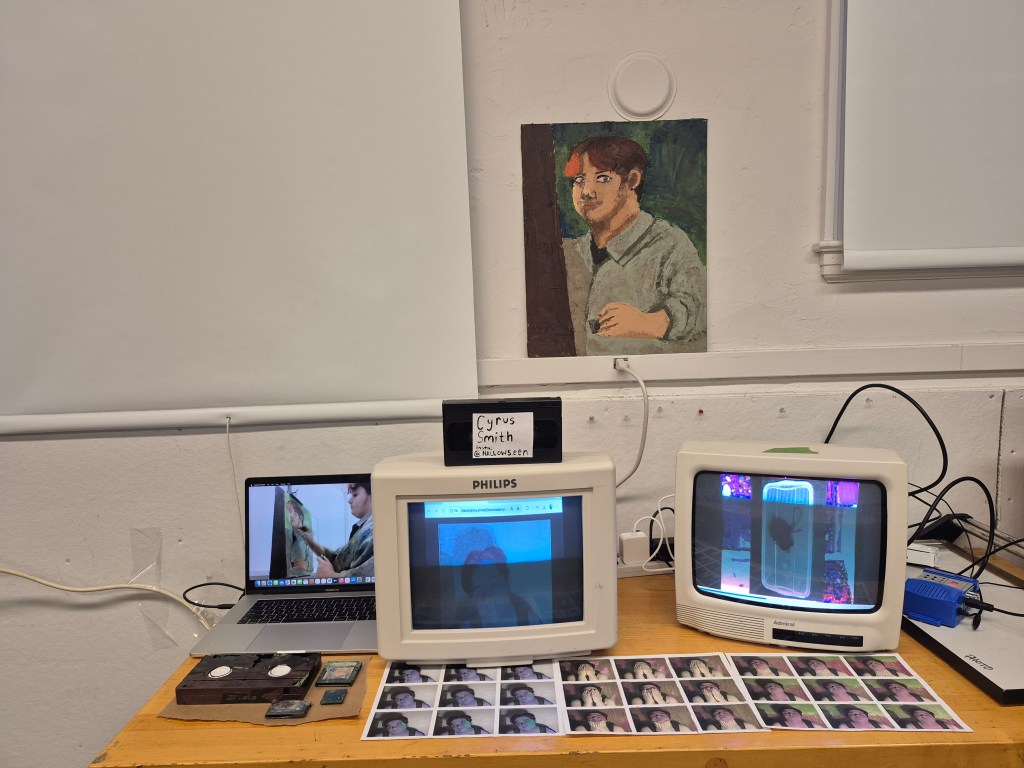 Picture of multiple screens show different videos with a painting above them.