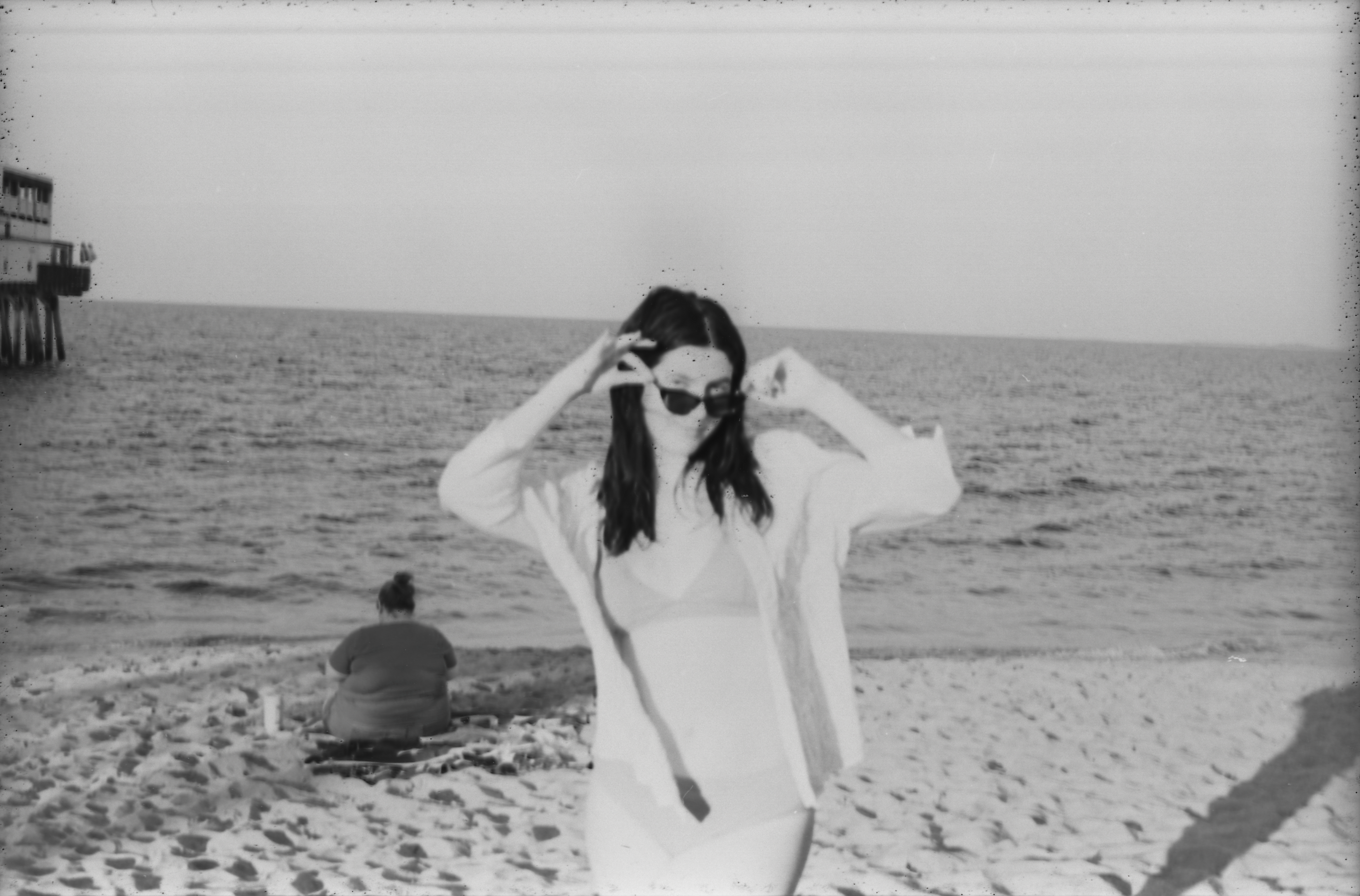 Black and white picture of a dark haired girl with sunglasses on.